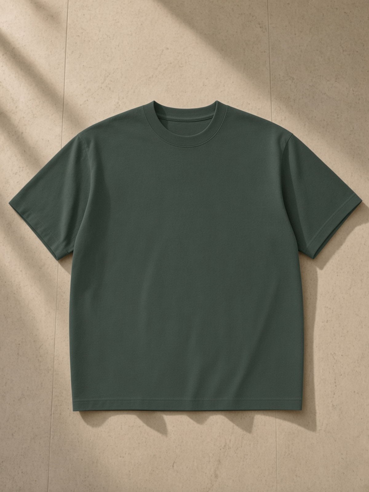 Sueded Cotton T-Shirt in Green, laid flat on pale limestone, front.