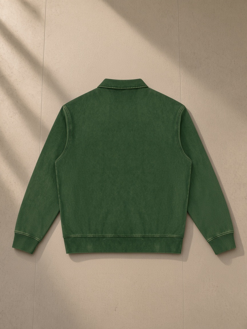 Vintage wash quarter-zip sweatshirt in Blackish Green, laid flat on pale limestone, back view