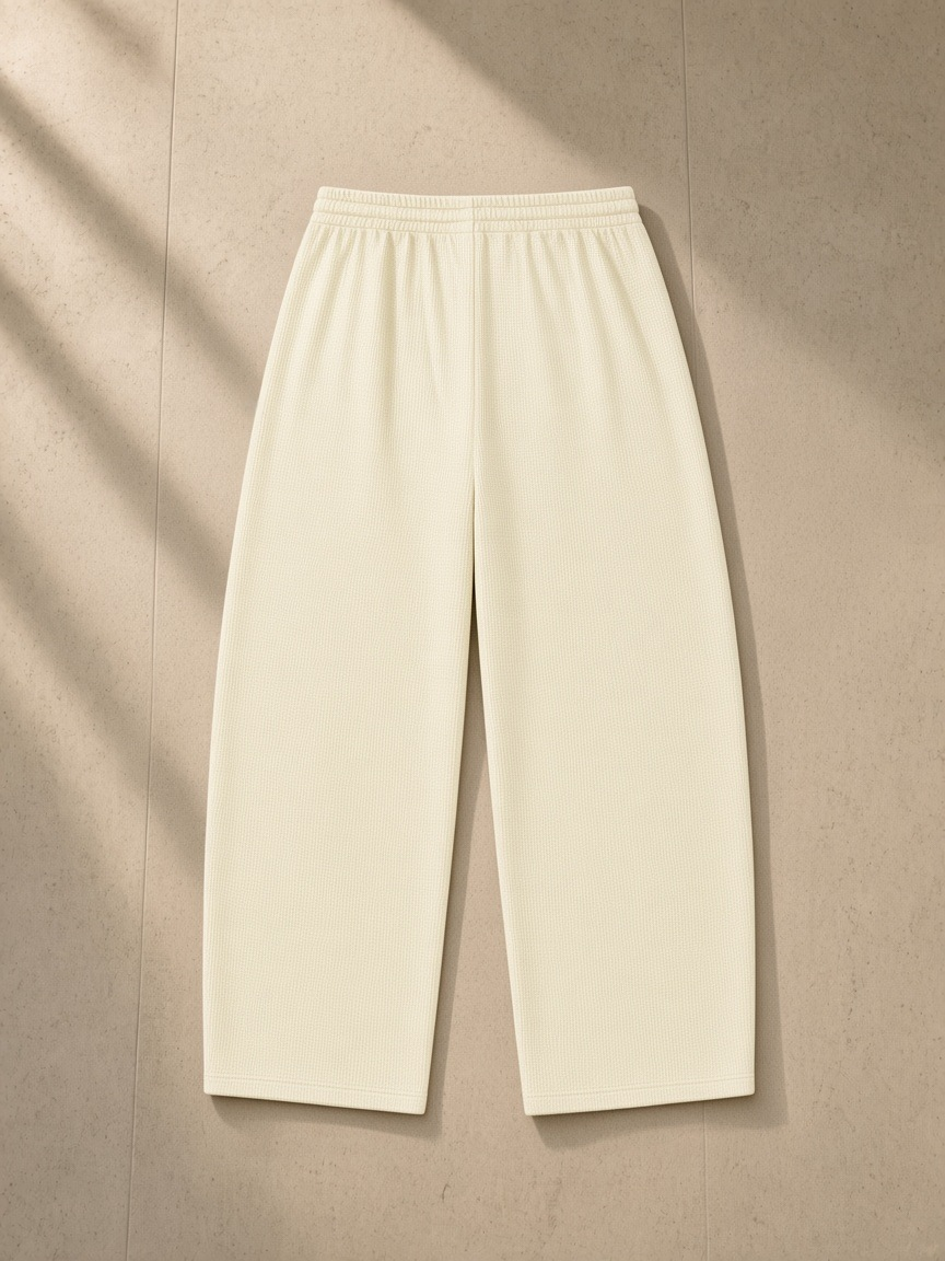 Waffle barrel leg pants in Mild Apricot, laid flat on pale limestone, back view