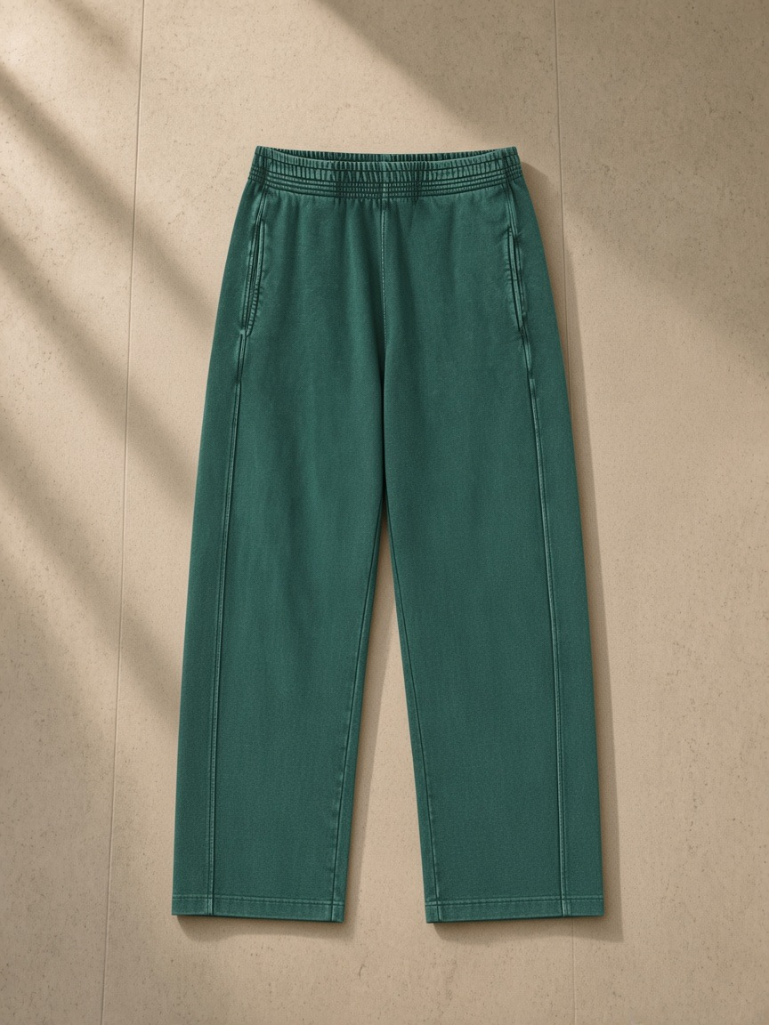 Mineral Wash Straight Sweatpants in Blackish Green, laid flat on pale limestone