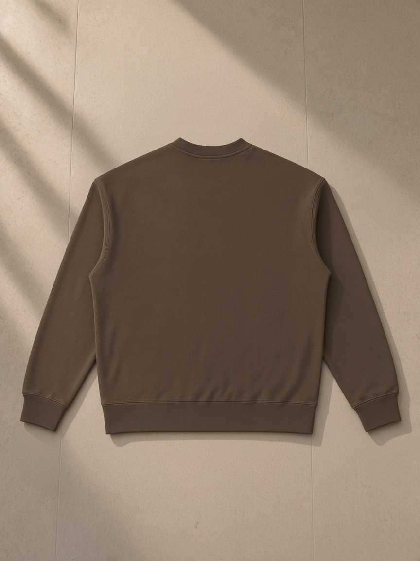 Heavyweight patch pocket crewneck sweatshirt in Coffee, laid flat on pale limestone, back view