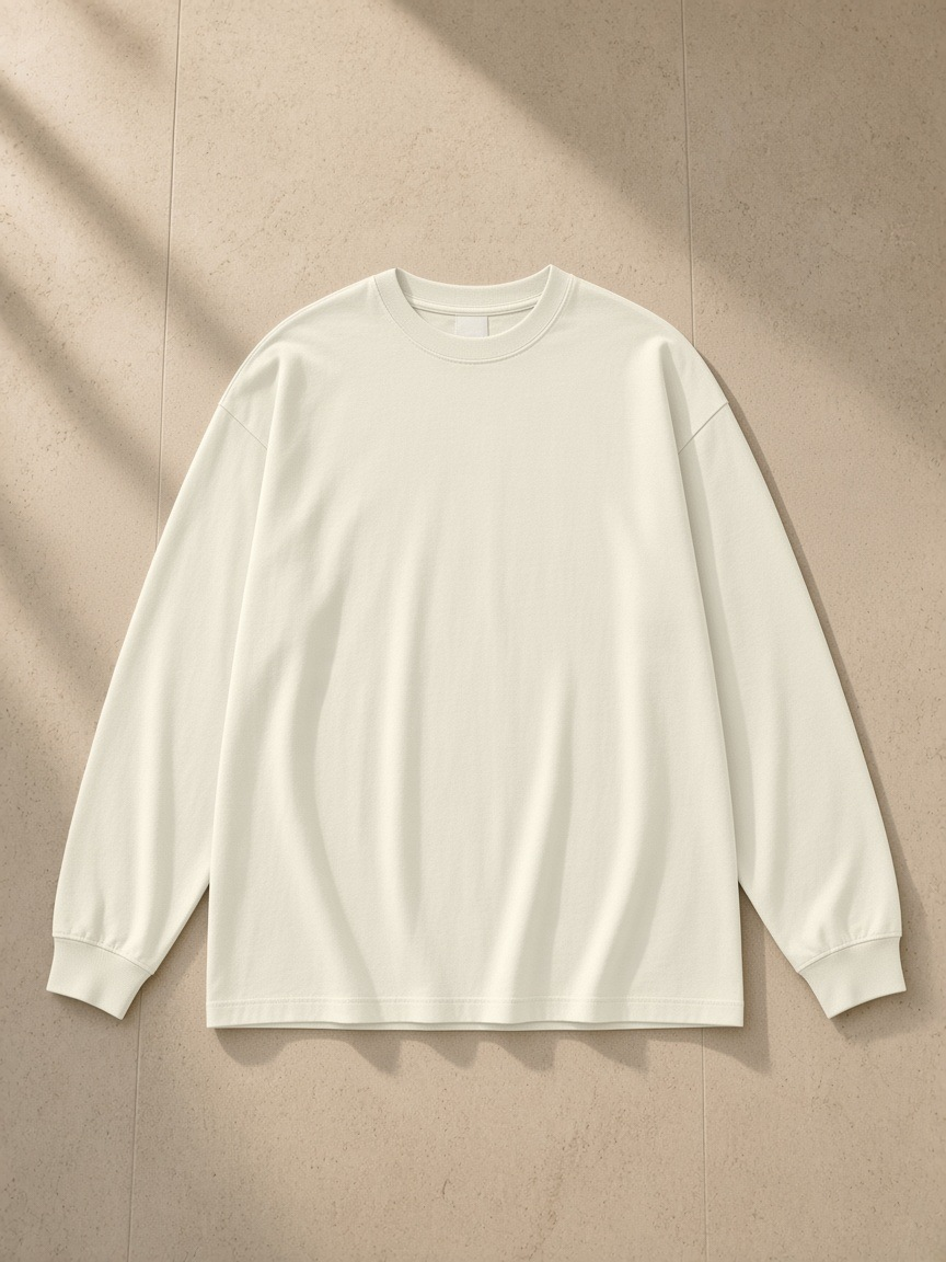 Oversized Long Sleeve T-Shirt in Milk Tea, laid flat on pale limestone