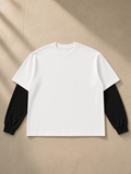 Layered contrast sleeve t-shirt in White with Black, laid flat on pale limestone