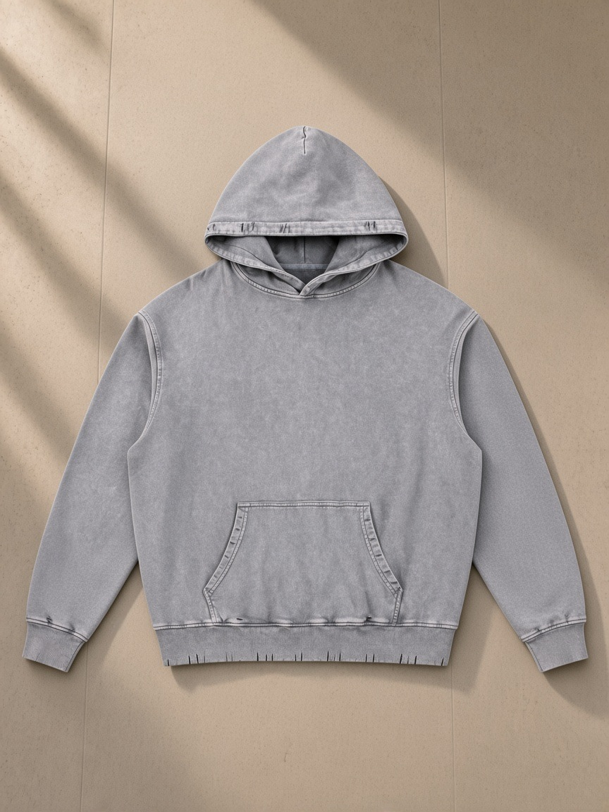 Snow Wash Hand-Frayed Heavyweight Hoodie in Light Gray, laid flat on pale limestone