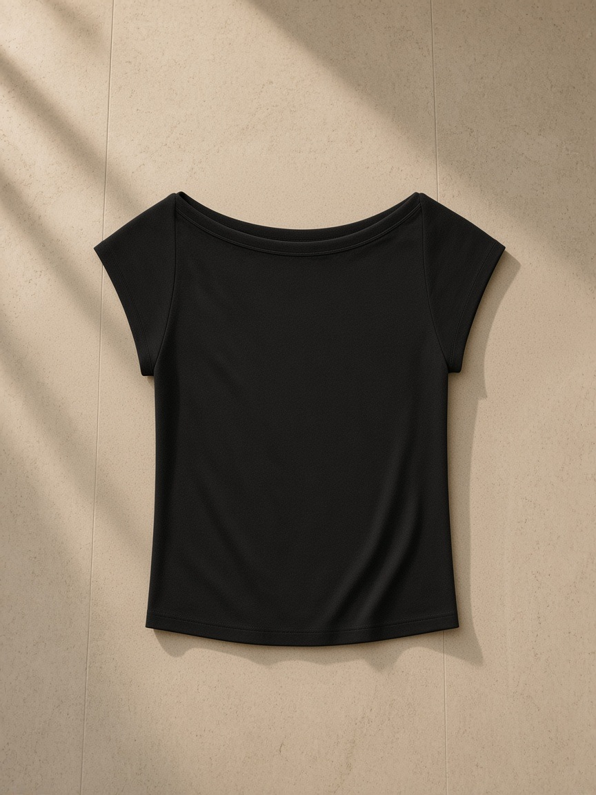 Wide neck baby t-shirt in Black, laid flat on pale limestone