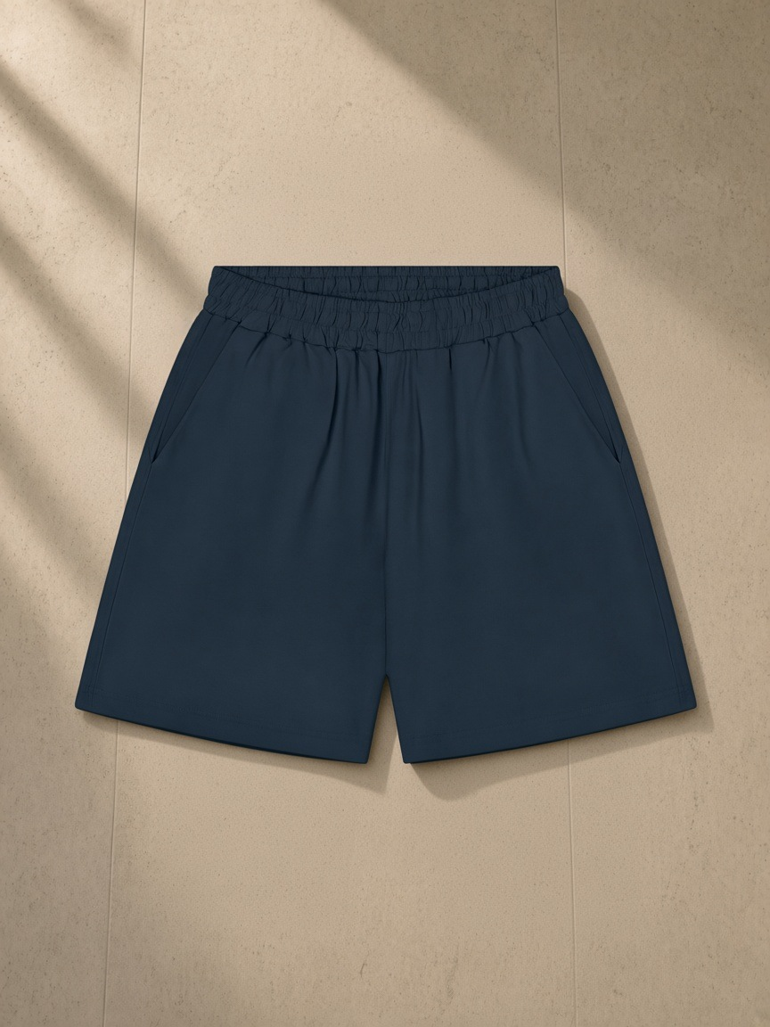 Unisex regular fit shorts in Navy Blue, laid flat on pale limestone