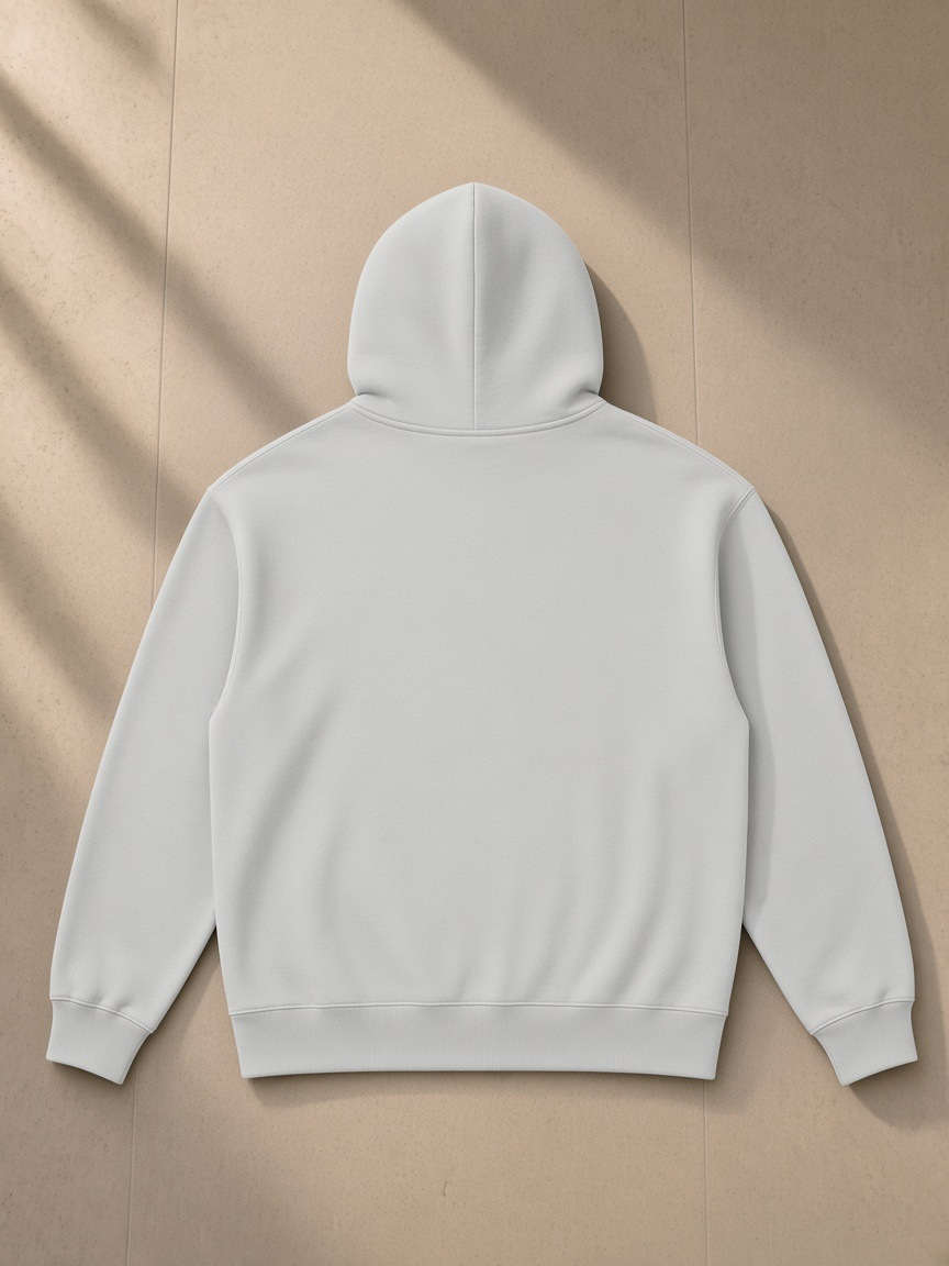 Heavyweight pullover hoodie in Light Gray, laid flat on pale limestone, back view