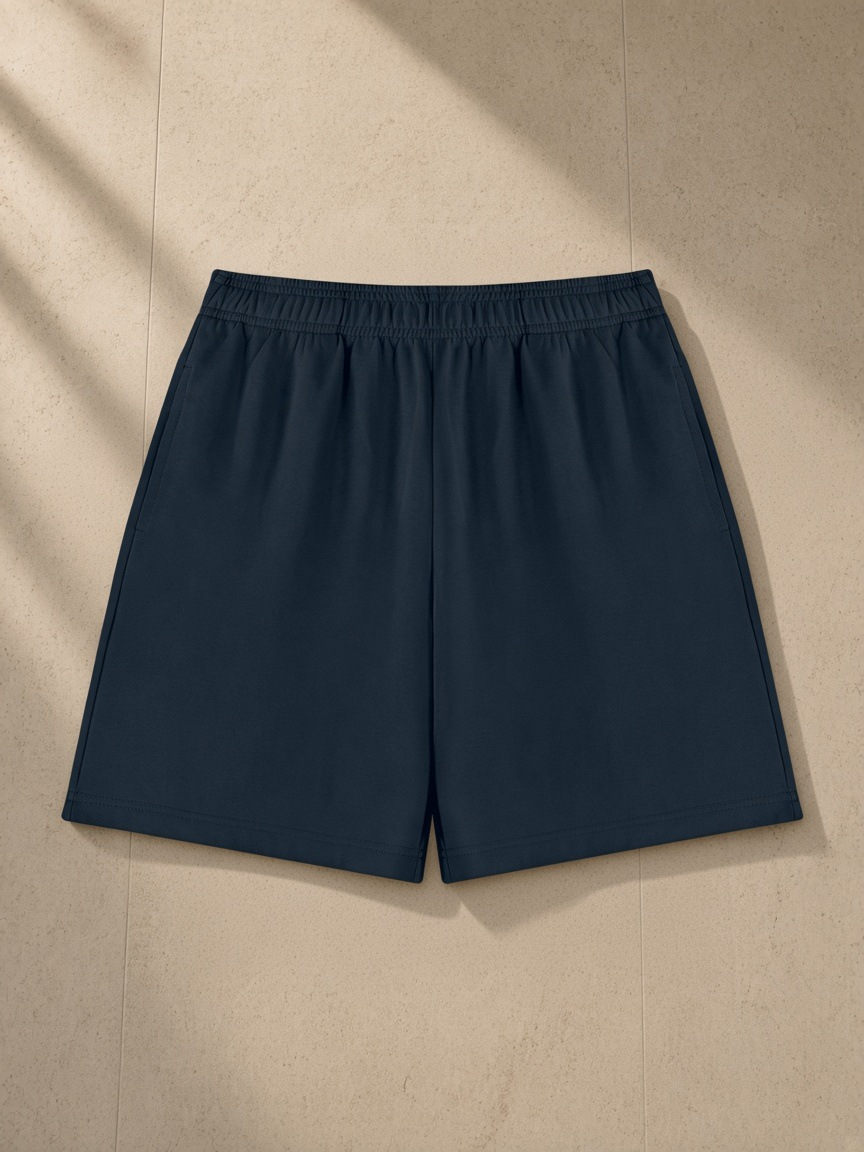 Cotton Shorts in Navy Blue, laid flat on pale limestone