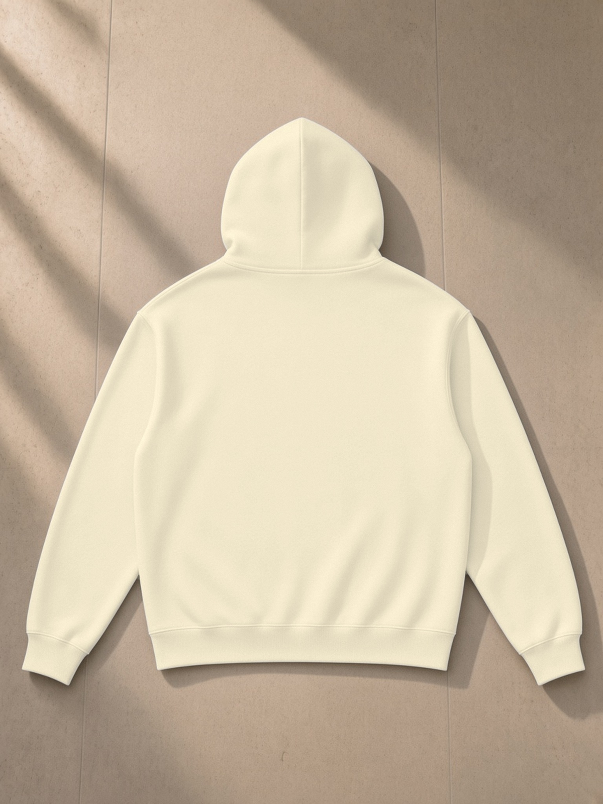 Essential Heavyweight Drop-Shoulder Hoodie in Mild Apricot, laid flat on pale limestone, back.