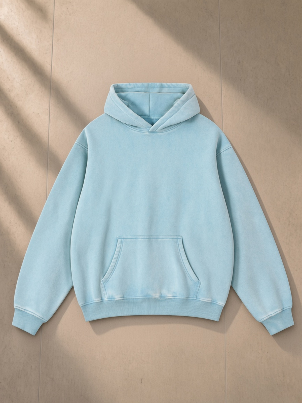 Snow Wash Fleece Oversize Hoodie in Lake blue, laid flat on pale limestone, front view
