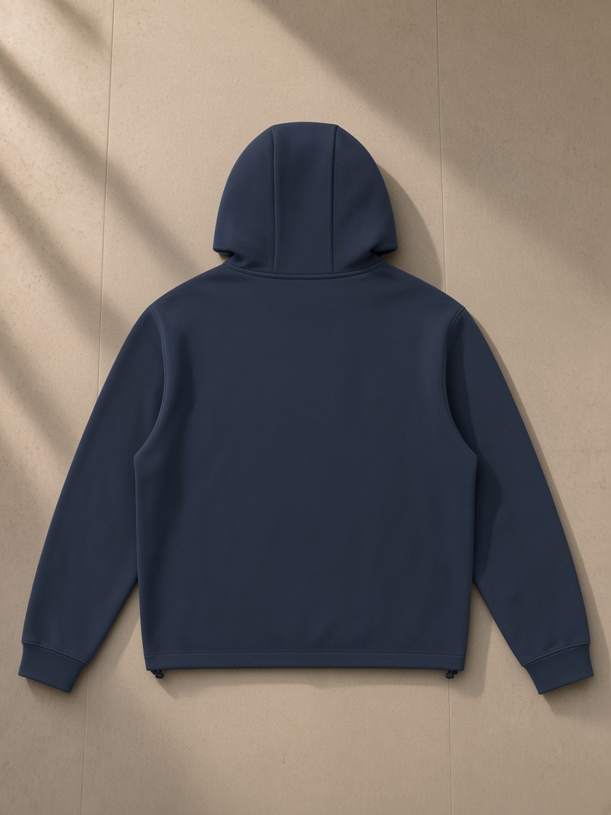 Unisex paneled full zip hoodie in Navy Blue, laid flat on pale limestone, back view