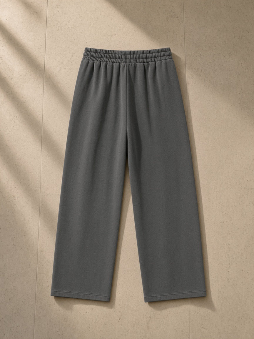 Heavyweight vintage wash sweatpants in Dark Gray, laid flat on pale limestone, back view