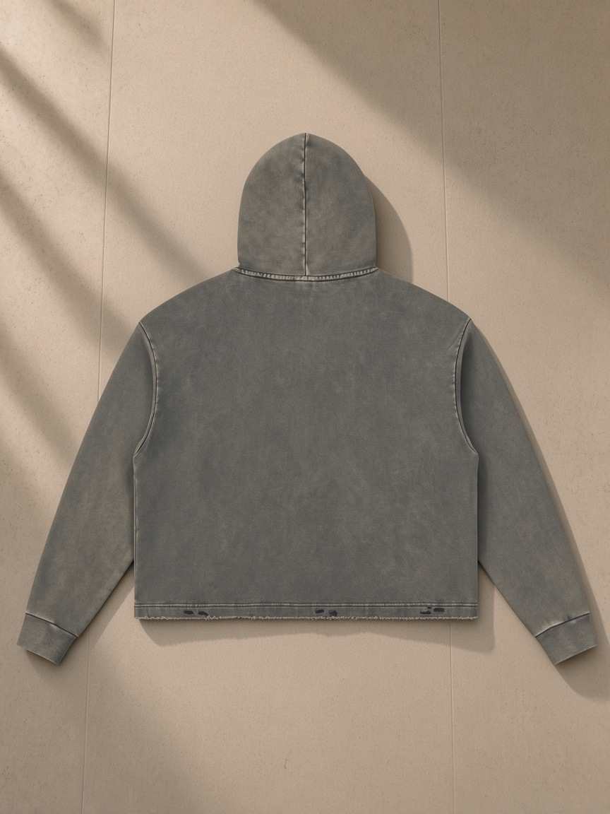 Vintage washed frayed-hem hoodie in Gray, laid flat on pale limestone, back view