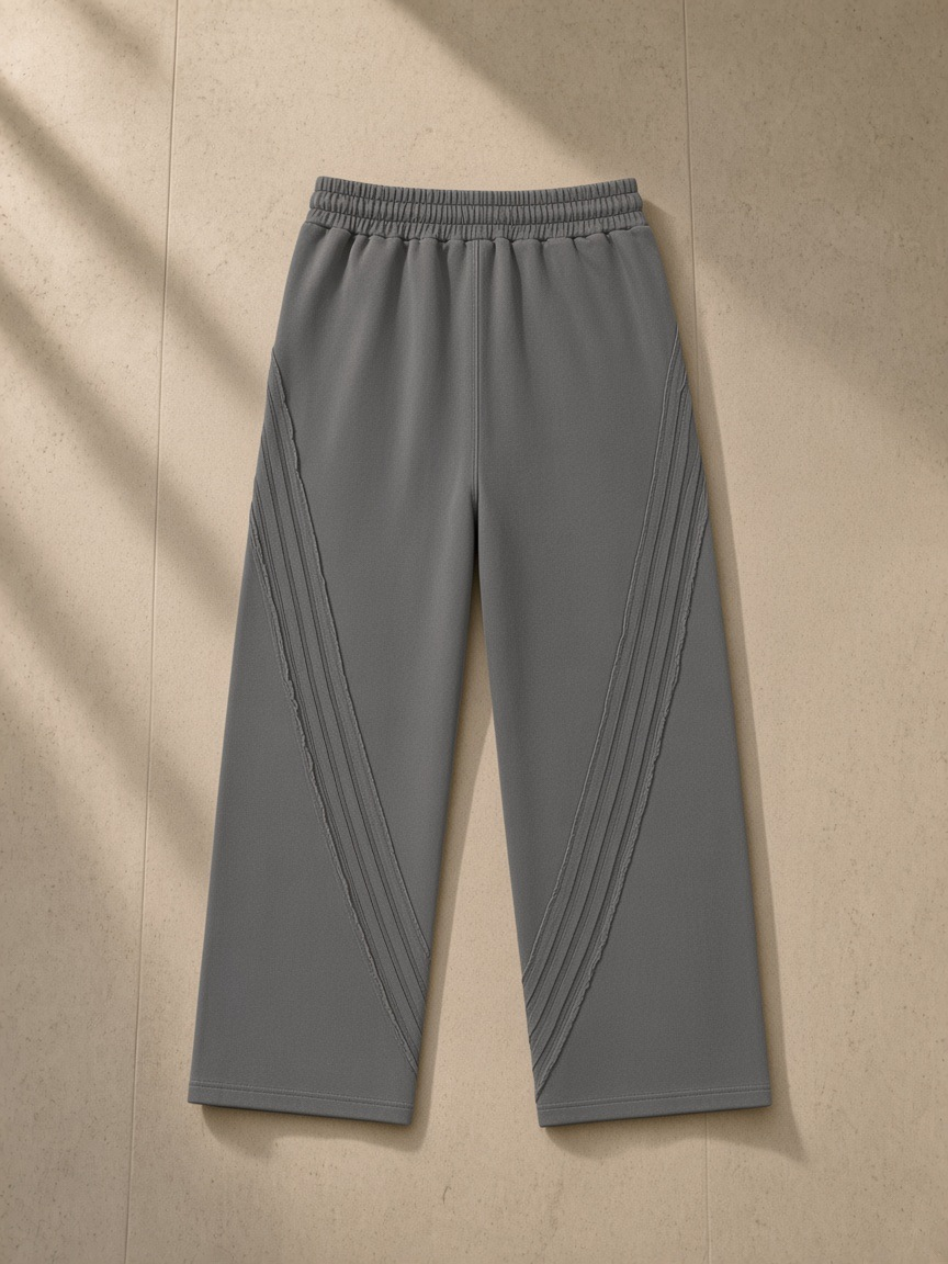 Snow Washed Tape Raw Edge Sweatpants in Dark Gray, laid flat on pale limestone, back view