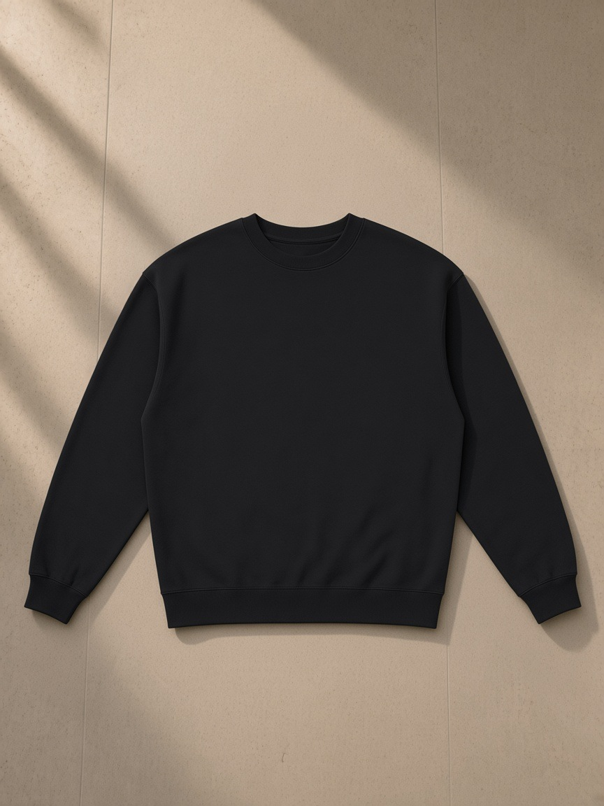 Loose Crewneck Sweatshirt in Black, laid flat on pale limestone, front.