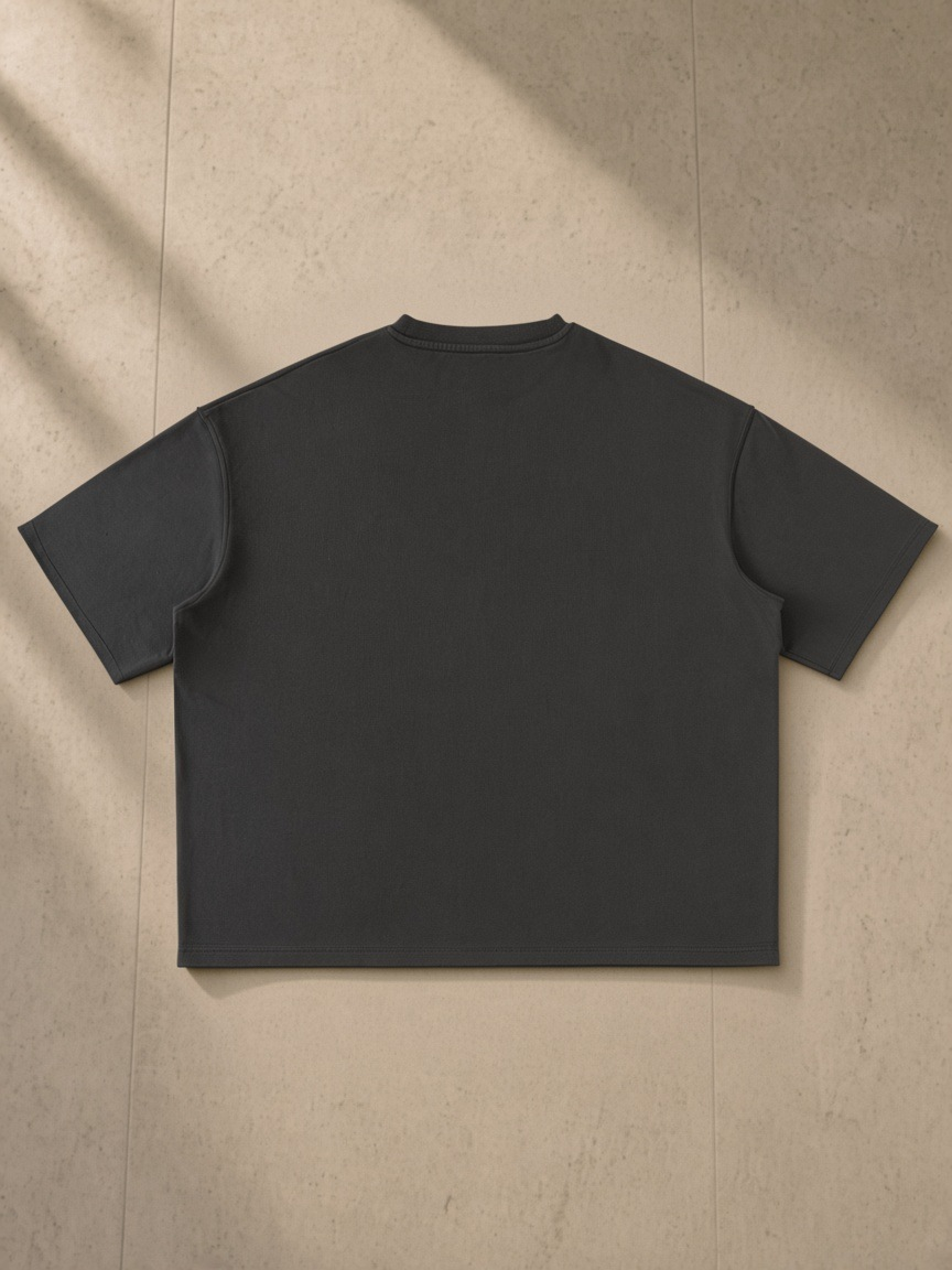 Washed Rolled Hem Half Sleeve T-Shirt in Dark Gray, laid flat on pale limestone, back.