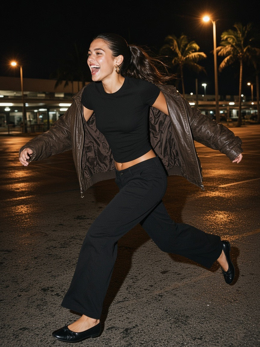 Two people in the Marcel Afters Fitted Crop Cotton T-Shirt in Black Beauty at private jet steps at night