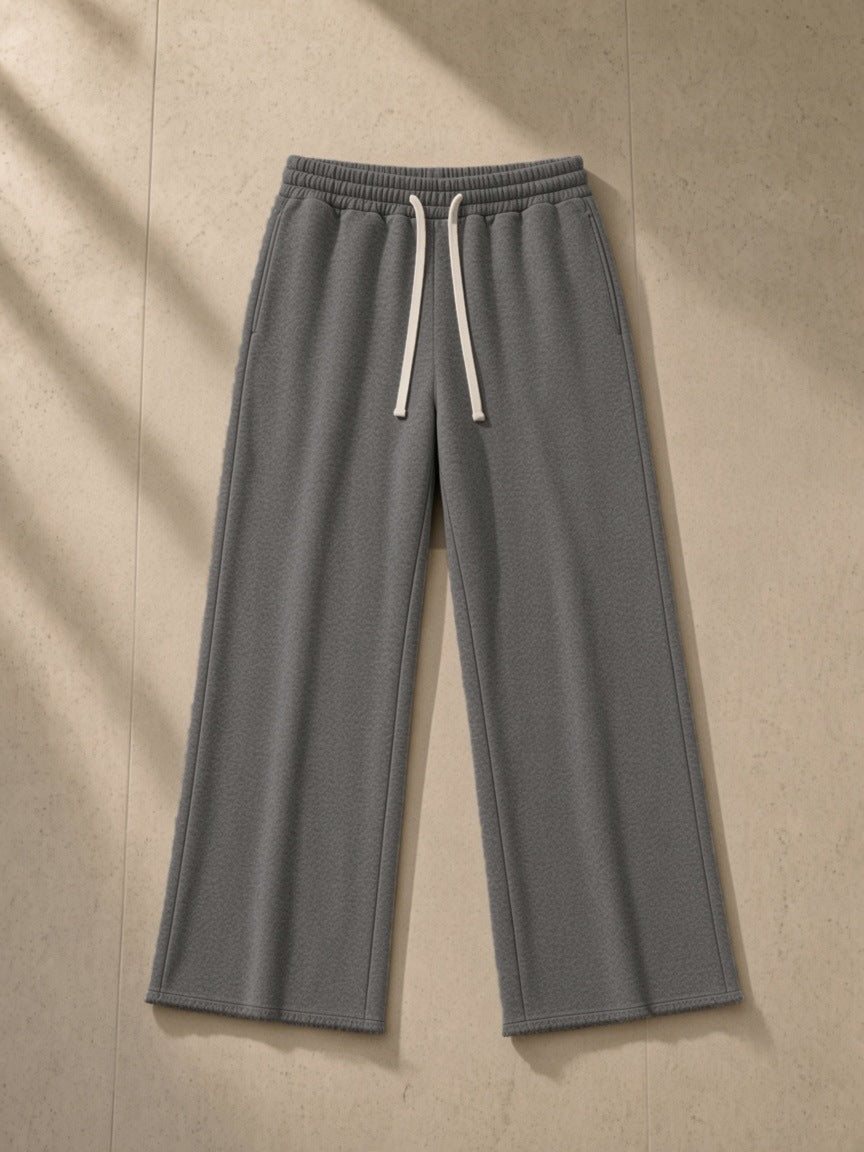 Flared Sweatpants in Gray, laid flat on pale limestone