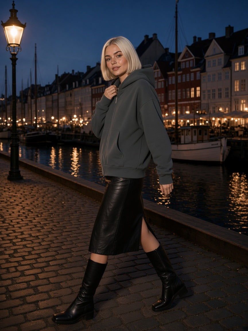 Woman in the Marcel Afters fleeced full-zip boxy hoodie in Charcoal Gray with black tailored trousers, at a black-stone infinity pool in Patagonia at blue hour