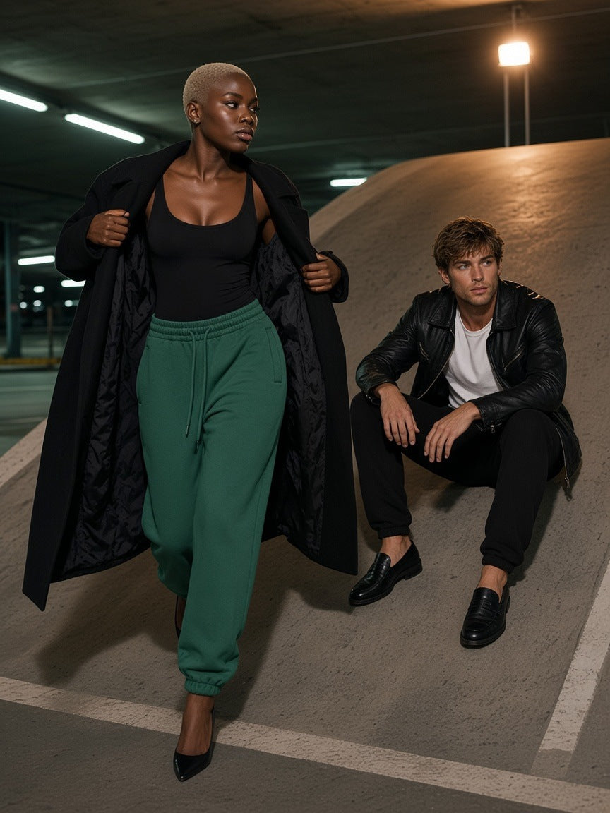 Two people in the Marcel Afters Fleeced Jogger Sweatpants in Black and Dark Green on a Copenhagen canal quay at night