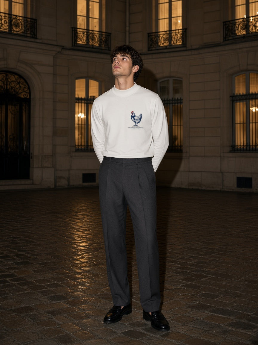 Man in the French Hen. No Apology mock neck sweatshirt in White in a Paris courtyard at night