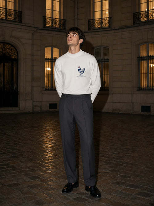 Man in the French Hen. No Apology mock neck sweatshirt in White in a Paris courtyard at night