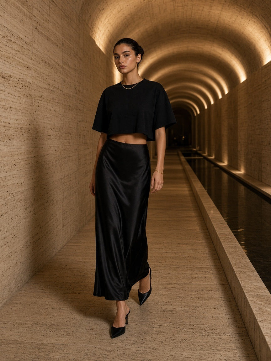 Woman in the Marcel Afters French Terry Raw Edge T-Shirt in Black in a travertine hotel spa corridor in Istanbul at night