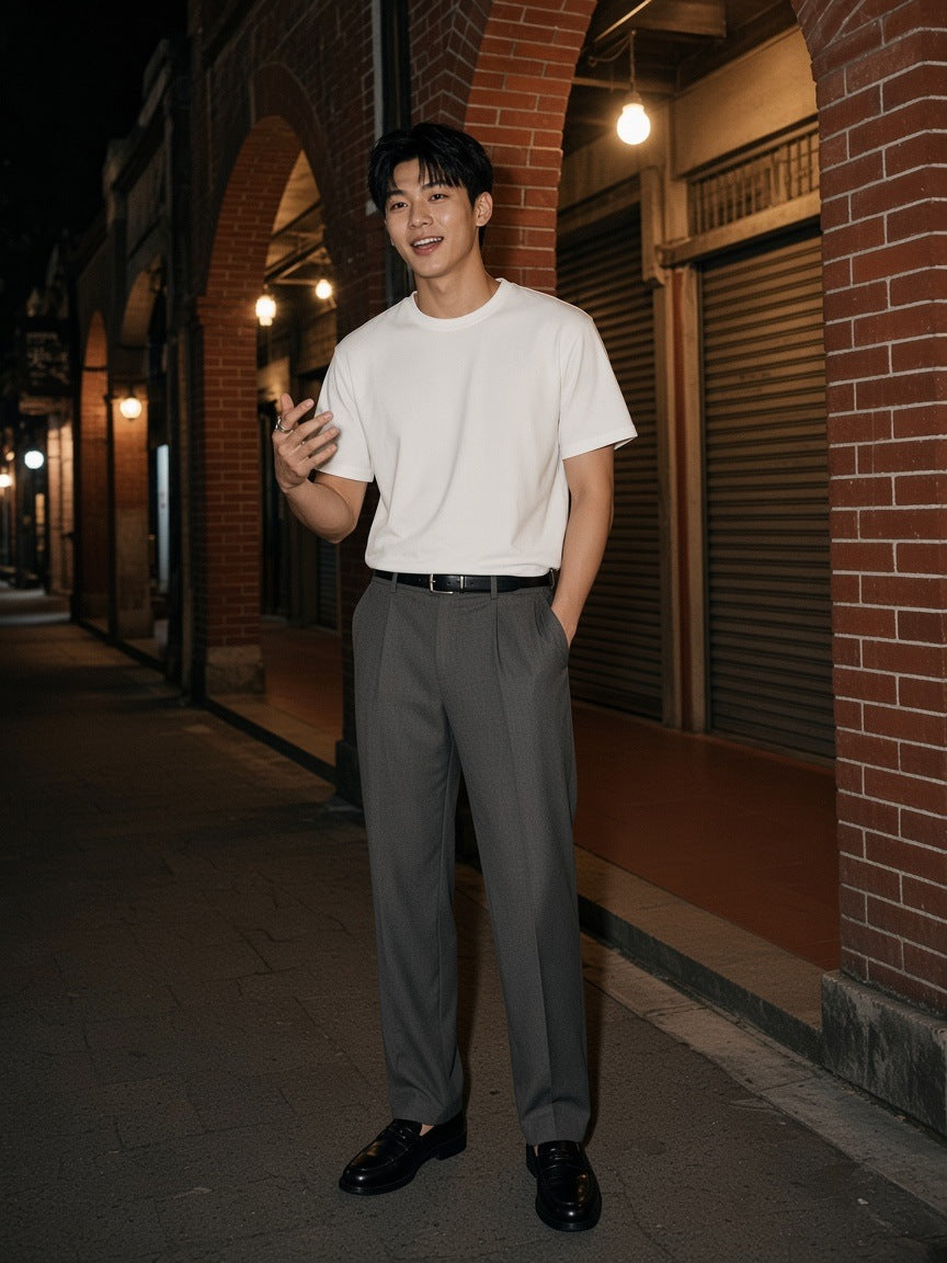 Man in the French Terry Raw Edge T-Shirt in White standing by a concrete facade in Aoyama, Tokyo at night