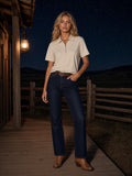 Woman in the Half-Zip Cotton Polo in Pale Khaki on a ranch porch in Wyoming at night