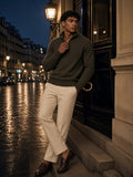Man in the Heavyweight Collared Quarter-Zip in Brown with cream trousers, leaning in a lantern-lit Paris doorway after rain