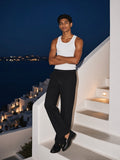 Man in Black heavyweight cotton straight-leg pants and a white tank on whitewashed island stairs at blue hour