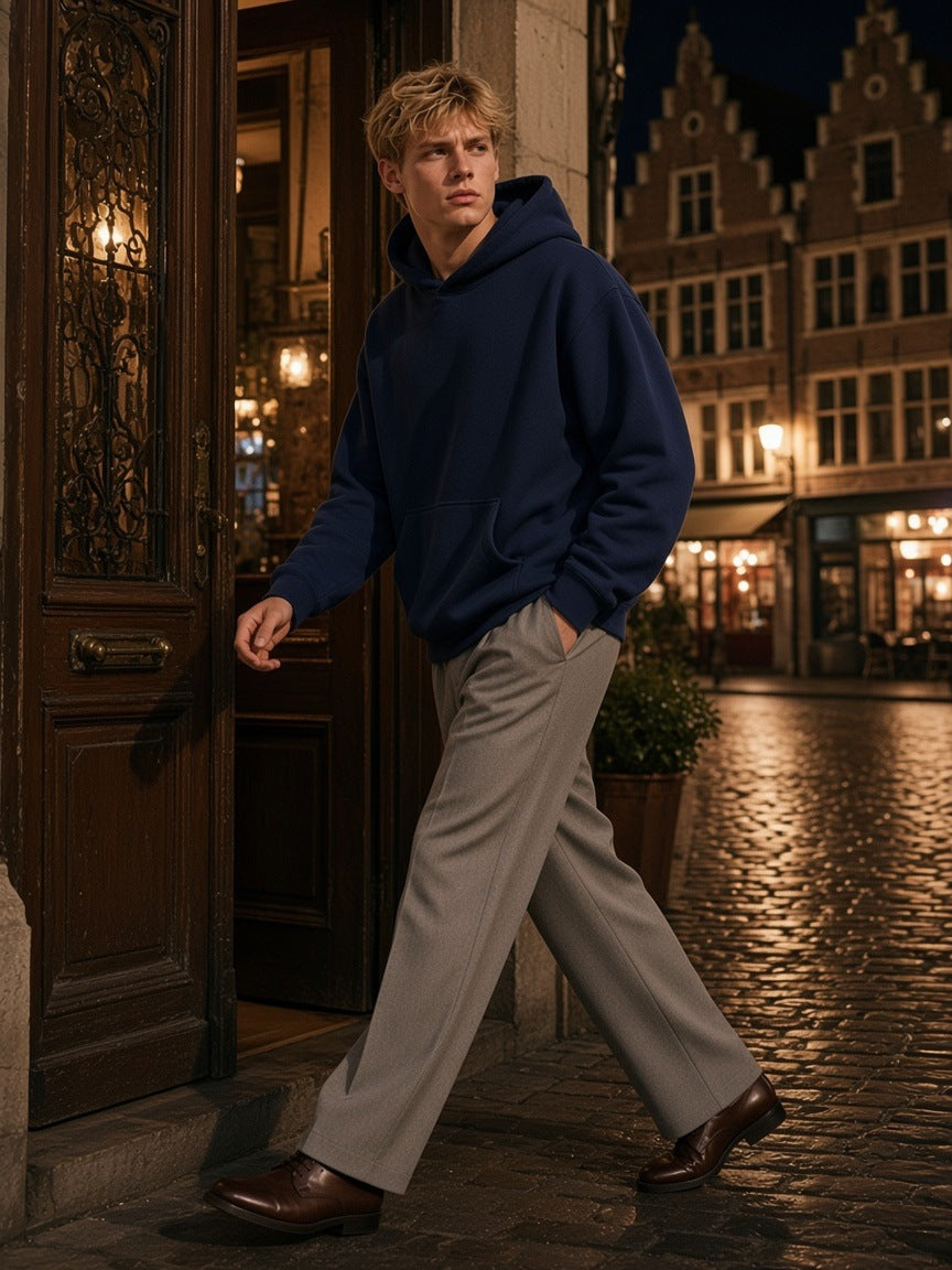 Man in the Marcel Afters heavyweight fleece boxy hoodie in Navy Blue standing on a canal bridge in Amsterdam at blue hour