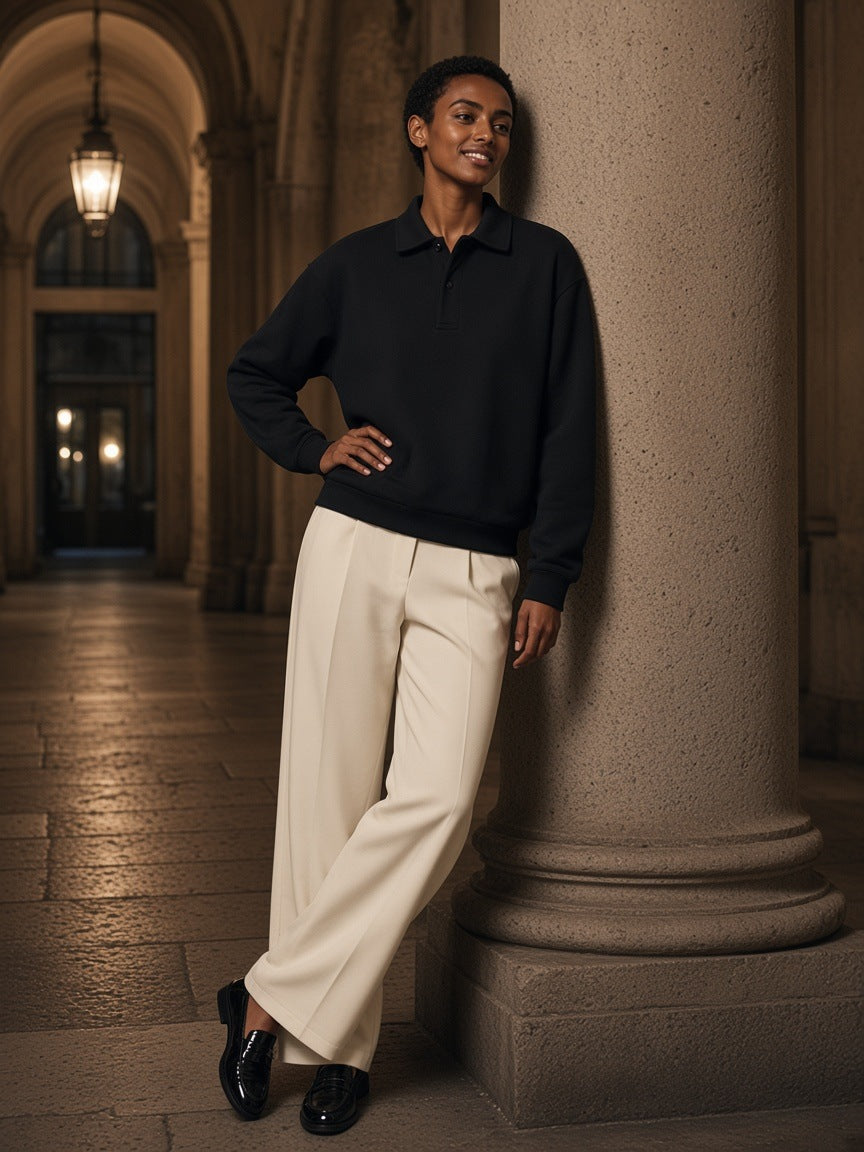 Woman in the Marcel Afters Heavyweight Fleece Polo Sweatshirt in Black in a palazzo courtyard in Milan at night