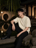 Man in the Heavyweight Knit Round Neck T-Shirt in Apricot in a teahouse garden in Hangzhou at night