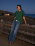 Woman in the heavyweight loose fit t-shirt in Forest Green leaning on a ranch fence in Big Sur, California at blue hour