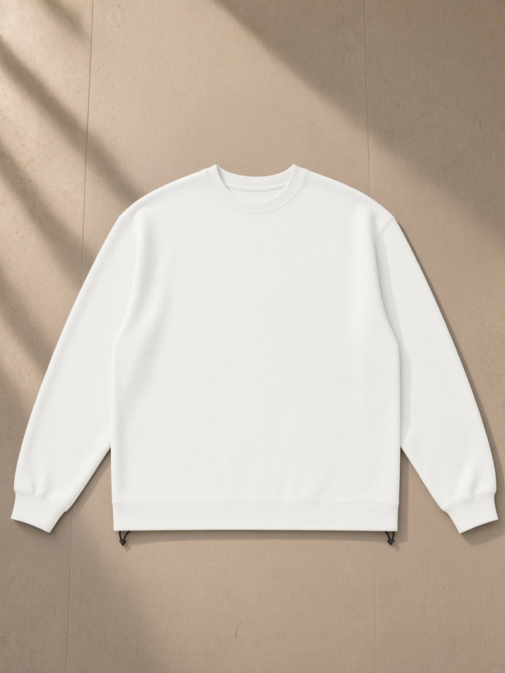 Heavyweight oversized boxy sweatshirt in White, laid flat on pale limestone, front view