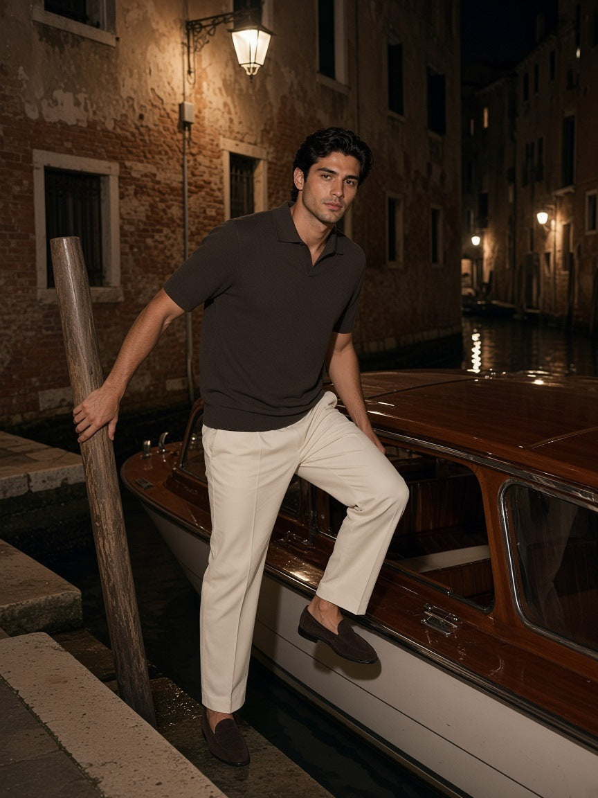 Man in the Marcel Afters heavyweight oversized polo shirt in Dark Brown standing on a canal-side fondamenta in Venice at night