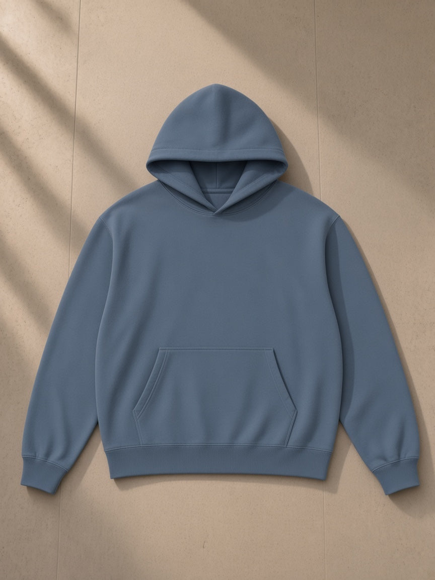 Heavyweight pullover hoodie in Gray Blue, laid flat on pale limestone, front view