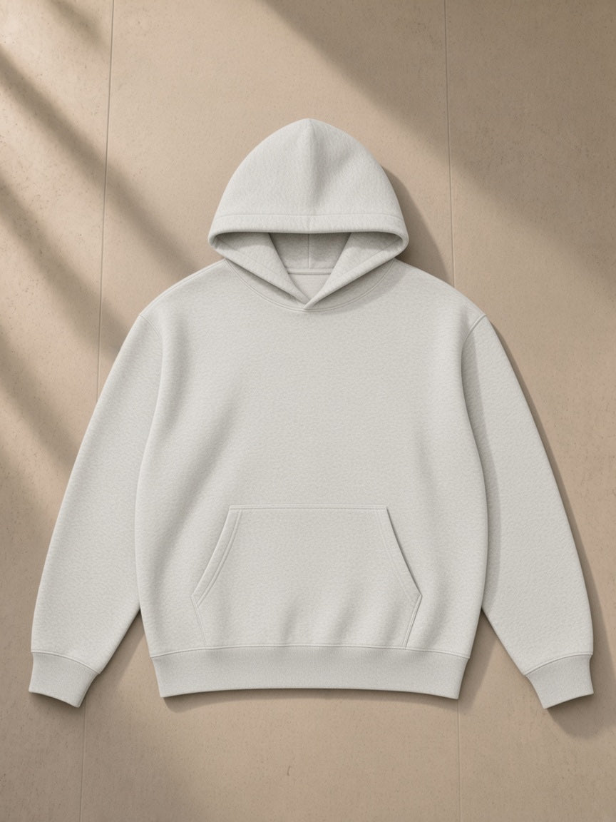 Heavyweight pullover hoodie in Oat Gray, laid flat on pale limestone, front view