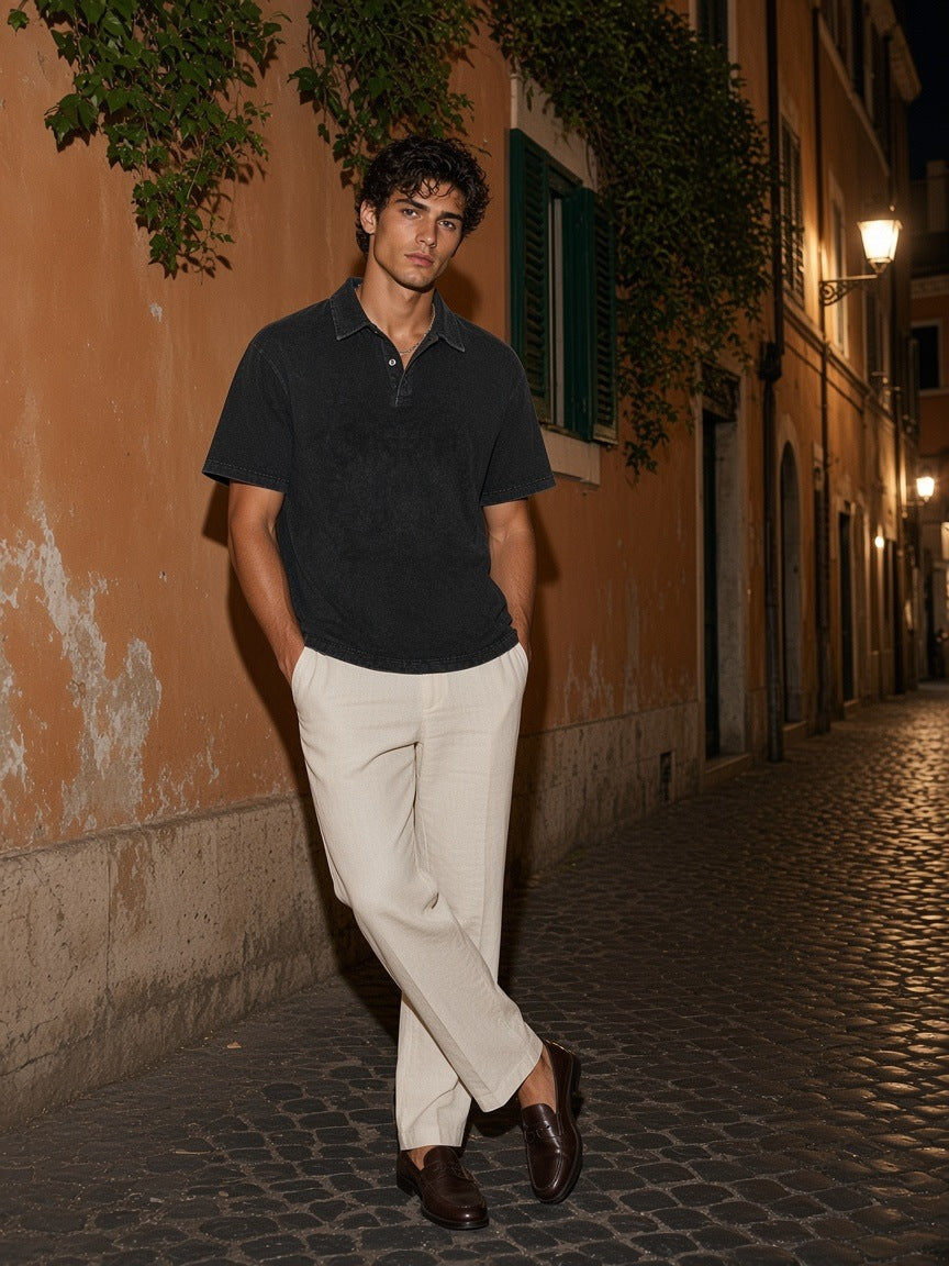 Man in the Marcel Afters Heavyweight Snow-Washed Polo in Black on a cobbled street in Rome at night