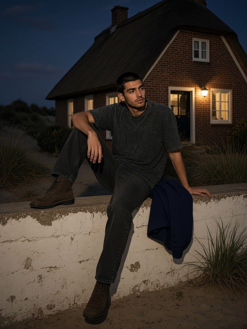 Two people in the Marcel Afters Heavyweight Snow Washed T-Shirt outside a thatched house on Sylt at night