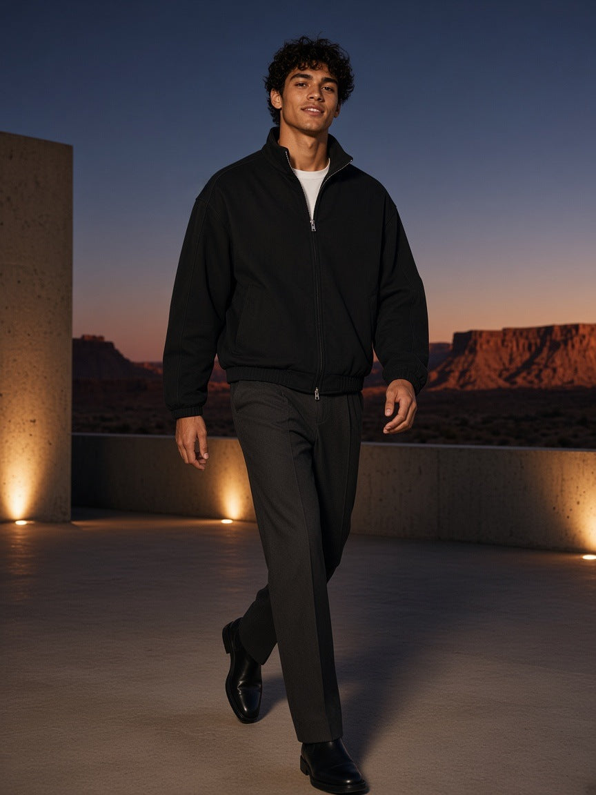 Man in the Heavyweight Stand Collar Jacket in Black, walking across a concrete courtyard in the Utah canyonlands at night
