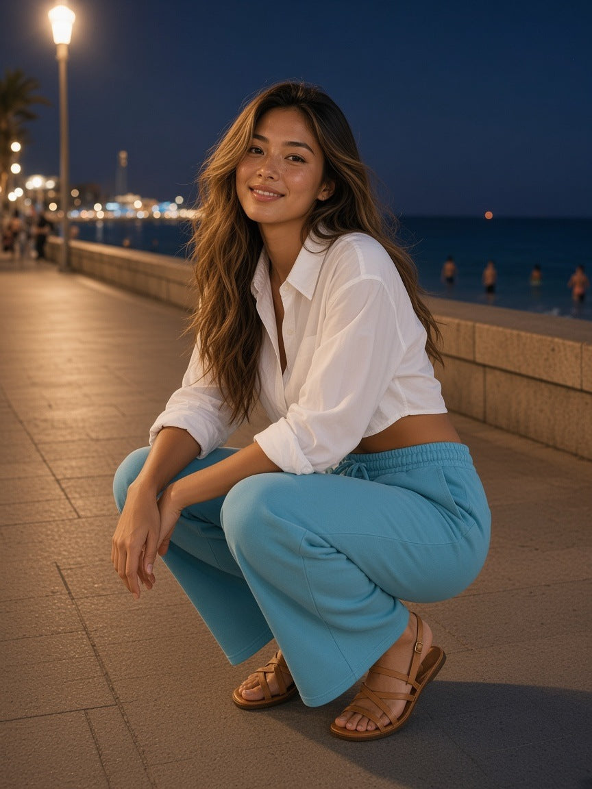 Woman in the Heavyweight Vintage Wash Sweatpants in Sky Blue on a whitewashed lane in Mykonos at night