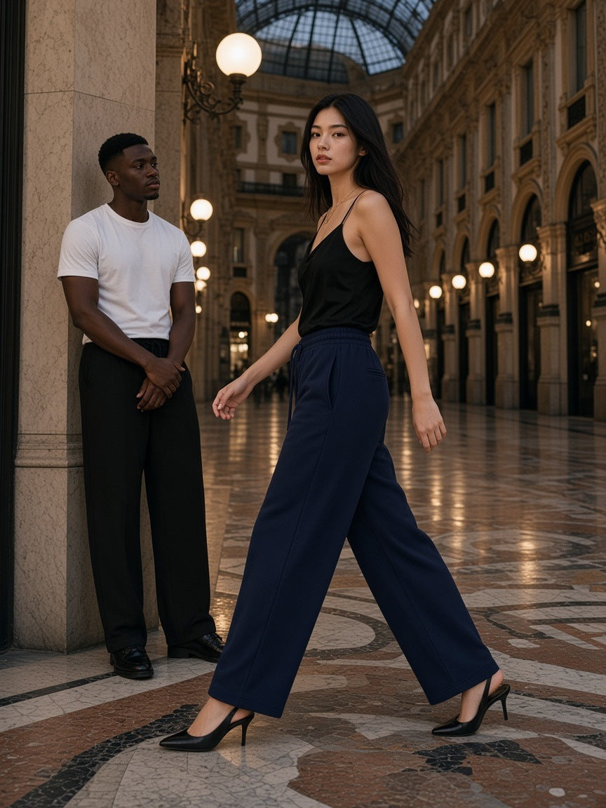 Two people in the Heavyweight Wide Leg Panel Sweatpants in Navy Blue and Black in the Galleria in Milan at night