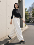 Woman in the Heavyweight Wide Leg Panel Sweatpants in White on a concrete street in Aoyama, Tokyo by day