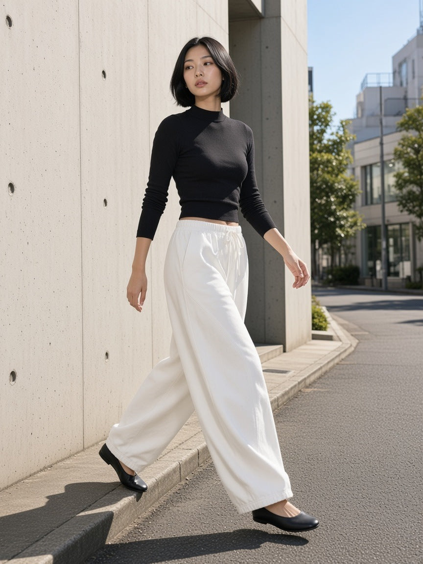 Woman in the Heavyweight Wide Leg Panel Sweatpants in White on a concrete street in Aoyama, Tokyo by day
