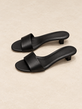 Black leather single-strap slide sandal, studio photograph