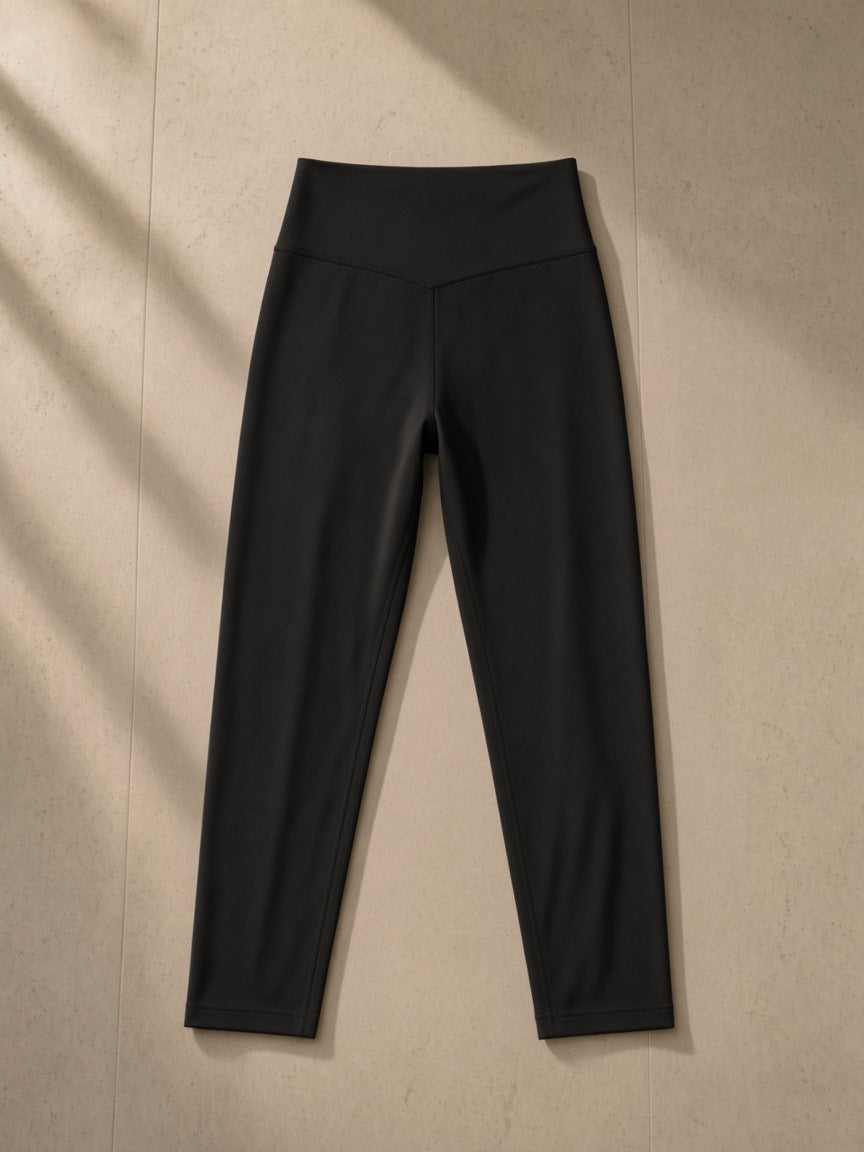 High-Waisted Yoga Leggings in Black, laid flat on pale limestone