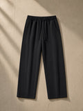 Heavyweight vintage wash sweatpants in Black, laid flat on pale limestone