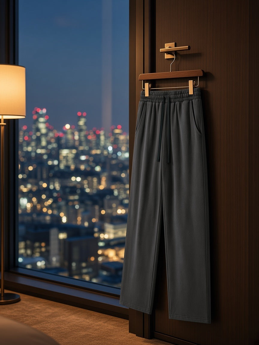 Heavyweight vintage wash sweatpants in Dark Gray on a wooden hanger in a Tokyo hotel suite at night
